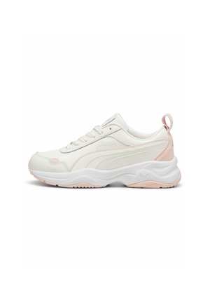 Baskets Puma blanches et rose clair avec lacets à l'avant, semelle épaisse et languette au talon, montrées de profil sur fond blanc.