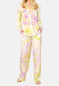 Květinový dvoudílný set z lehkého a hladkého materiálu. Krémový základ s růžovými a zelenými vzory. Košile s dlouhým rukávem a kalhoty s širokými nohavicemi.