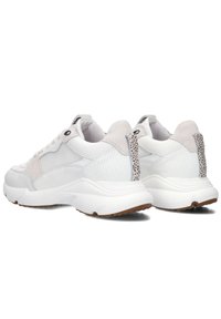 White sneakers featuring a mixed material design with suede and mesh. Thick sole with a textured heel detail and contrasting accents.