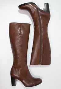 Bottes hauteur genou en cuir marron avec une texture lisse, dotées d'une fermeture éclair latérale, d'un talon haut et d'une forme élégante.