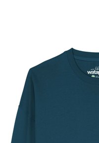 Dunkeltürkisfarbiges Langarmshirt mit Rundhalsausschnitt, gerippten Bündchen und glatter Textur. Verfügt über ein Logo-Label am Hals.