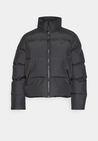 Giubbotto imbottito nero con colletto alto, chiusura con zip e tasche laterali. Presenta sezioni trapuntate e un design slim fit.