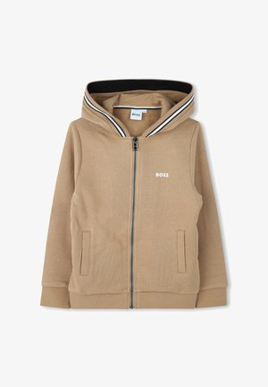 Sweat-shirt zippé à capuche beige, avec un col rayé noir et blanc, deux poches latérales et un logo sur la poitrine gauche.