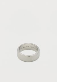 Ασημί μεταλλικό δαχτυλίδι με λεπτές οριζόντιες χαράξεις και «Tommy Hilfiger» χαραγμένο στην εσωτερική πλευρά της ταινίας.