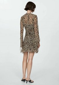 Rochie transparentă cu imprimeu leopard, cu mâneci lungi, o siluetă ajustată și o fustă evazată. Dispune de legături laterale pentru ajustabilitate și un decolteu la spate.