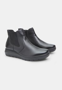 Stivali alla caviglia in pelle nera con pannelli laterali elastici e suola in gomma texture, caratterizzati da una finitura liscia e un design con punta arrotondata.