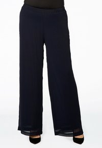 Wijdvallende broek in marineblauw, gemaakt van lichtgewicht materiaal. Heeft een elastische tailleband en doorzichtige accenten aan de onderzoom.