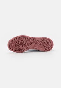 Baltas sneakeris ar teksturētu gumijas zoli bordo krāsā. Iezīmēts ar apaļu rakstu un adidas zīmolu sānu daļā.