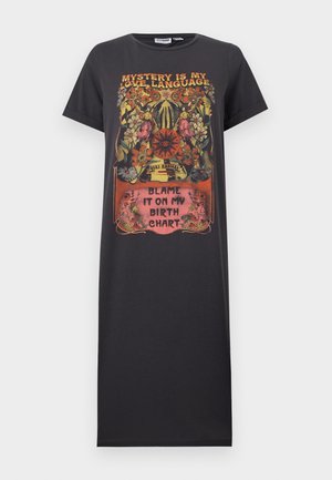 Μαύρο φόρεμα με κοντά μανίκια, με πολύχρωμο λουλουδάτο και μυστηριώδες σχέδιο. Το κείμενο γράφει «Το μυστήριο είναι η γλώσσα της αγάπης μου» και «Φταίει το αστρολογικό μου ωροσκόπιο».