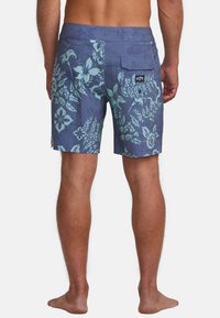Pantaloni da nuoto blu navy realizzati in tessuto leggero, con un motivo floreale in tonalità azzurra chiara; dotati di una tasca sul retro con chiusura a bottone.