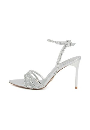 Sandalo argentato con tacco alto e sottili cinturini intrecciati sulle dita dei piedi e intorno alla caviglia, con chiusura a fibbia e design a punta.