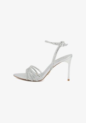 Sandalo argentato con tacco alto e sottili cinturini intrecciati sulle dita dei piedi e intorno alla caviglia, con chiusura a fibbia e design a punta.