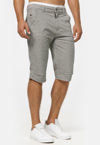 Checkered shorts with a casual fit, made from lightweight fabric. Features a button closure, side pockets, and rolled cuffs.