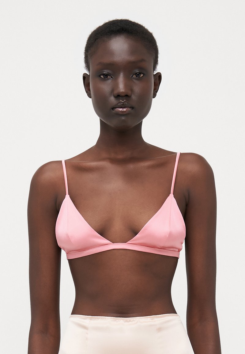 Sostenedor triangular rosa con finas correas ajustables, textura satinada suave y sin relleno. Diseño simple con un estilo minimalista.