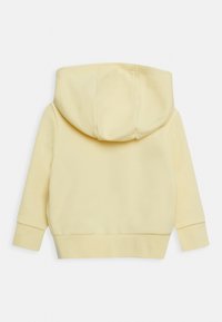 Sudadera de algodón amarilla con una capucha grande y redondeada, puños y dobladillo de canalé. Textura suave, sin patrones ni logotipos, vista trasera mostrada.