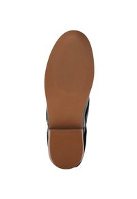 Suela de zapato negra hecha de goma, con la parte inferior marrón texturizada y surcos horizontales para mayor tracción. Diseño plano, forma redondeada.