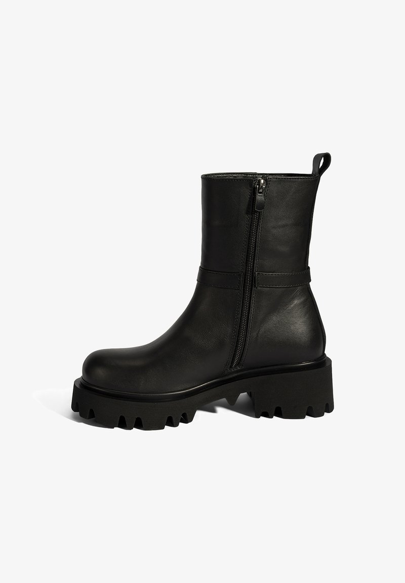 Black leather ankle boot with a rounded toe, side zipper, and chunky, ridged black rubber sole. Features a smooth finish and minimal accents.