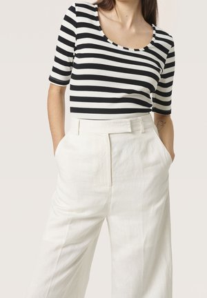 Top ajusté à rayures noires et blanches avec un col en scoop, associé à un pantalon en lin blanc taille haute avec des poches latérales.