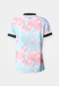 Lühikeste varrukatega särk pastellroosade ja siniste sfääriliste mustritega, vertikaalsete joontega, musta krae ja varrukaäärtega ning väikese kirjaga krae all.