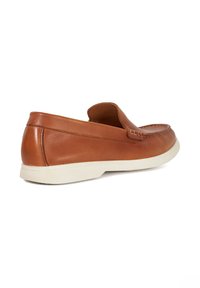Brown leather loafers with a stitched design and a low white rubber sole; features a rounded toe and slip-on style.