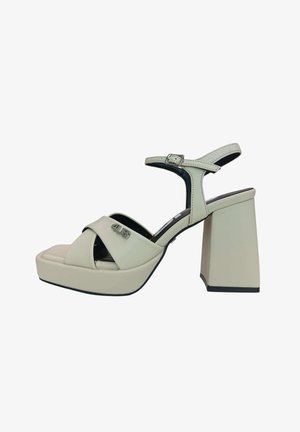 Sandalo platform beige con tacco a blocco, cinturino alla caviglia con fibbia, cinturini anteriori incrociati e logo metallico "4US" sul lato.