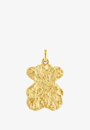Colgante en forma de osito de oro con superficie texturizada e irregular y un pequeño lazo para sujetarlo a una joya. La forma recuerda el contorno estilizado de un oso.