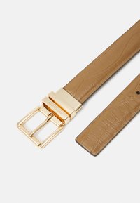 Cintura in finta pelle marrone con finitura testurizzata, dotata di una fibbia in metallo dorato di forma rettangolare con accenti incisi.
