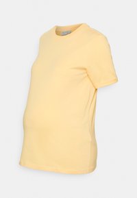 T-shirt de maternidade amarelo feito de algodão macio, apresenta mangas curtas, um decote redondo e um corte suavemente curvado para acomodar uma barriga em crescimento.