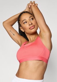 Ροζ αθλητικό σουτιέν με απαλό υφή, ελάχιστες ραφές και διάτρητες λεπτομέρειες για καλύτερη αναπνοή. Απλός σχεδιασμός με λαιμόκοψη τύπου crew neck.
