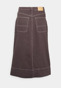 Jupe midi marron foncé avec un large ourlet, deux poches carrées à l'arrière, des surpiqûres blanches contrastantes, et un petit patch de marque beige sur la taille.