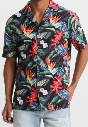 Chemise à manches courtes avec un fond noir présentant des motifs floraux tropicaux vibrants en rouge, orange, blanc et vert. Conception à boutons sur le devant.