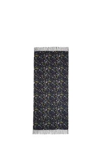 Sciarpa nera con motivo floreale e botanico, bordi frangiati e una texture morbida. Ha una forma rettangolare con colori vivaci.