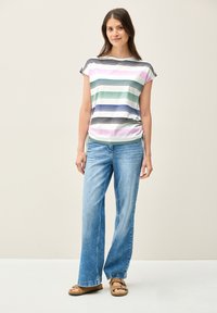 Stribet kortærmet skjorte i lyse farver med grønne, blå og pink striber. Kombination med lyseblå vide jeans og brune sandaler.