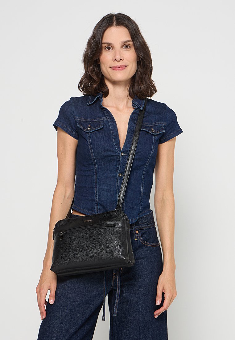 Schwarze Leder-Umhängetasche mit strukturiertem Finish, mit Reißverschlussfächern und verstellbarem Tragegurt. Kompakte Gestaltung, ideal für den täglichen Gebrauch.