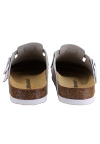 Sandales grises à enfiler avec une semelle intermédiaire en liège et une semelle extérieure en caoutchouc blanc. Elles sont dotées d'une texture lisse et d'un design minimaliste avec des découpes latérales.