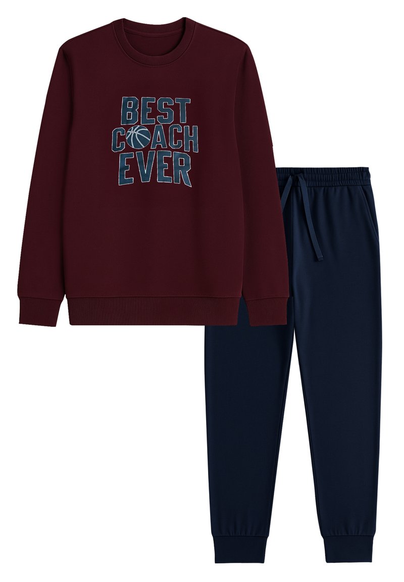 Burgundy sweatshirt med trycket "BÄSTA COACHEN NÅGONSIN" och marinblå joggerbyxor. Mjuk tyg, ribbad mudd och elastisk midja för komfort.