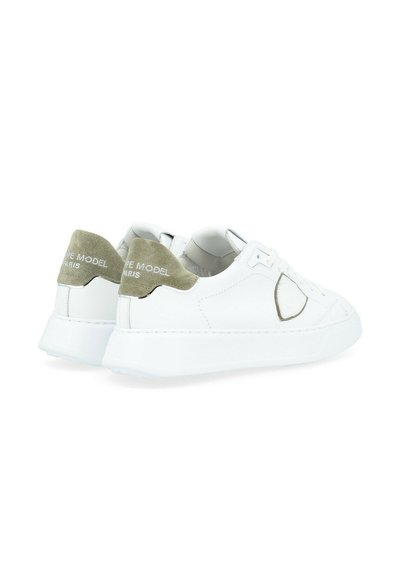 Sneakers bianchi in pelle con un tallone in suede verde oliva testurizzato. Presentano un design cucito e una suola in gomma per una migliore aderenza.