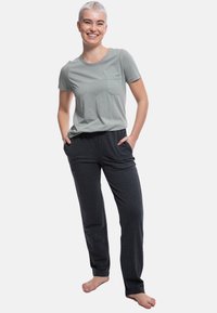 T-shirt in cotone grigio chiaro con taschino sul petto abbinato a pantaloni della tuta grigio scuro con tasche laterali, vestibilità comoda e texture morbida.