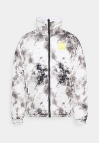 Kurtka puchowa w czarno-białym wzorze tie-dye, lekki materiał, wysoki kołnierz, zamek błyskawiczny z przodu oraz dzianinowe mankiety z wyrazistym detalem logo.