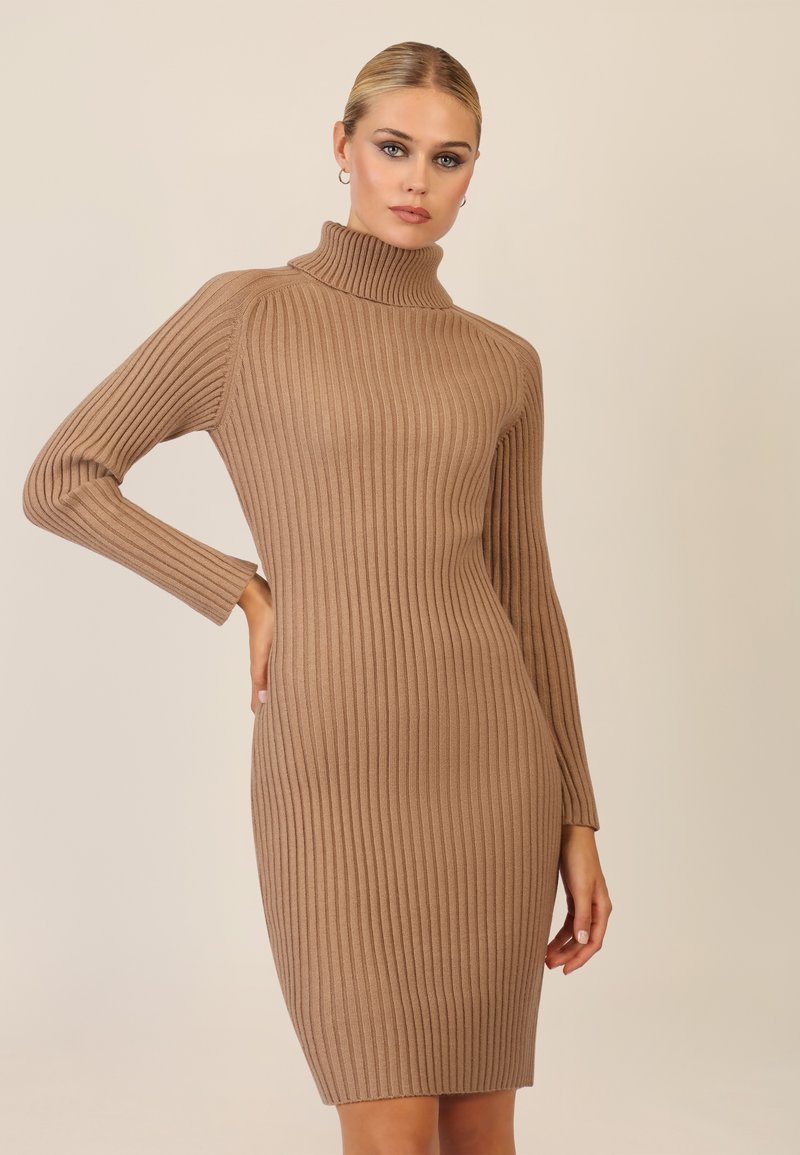 Strikket turtleneck kjole i lys brun; fremhæver lodret ribbemønster, lange ærmer, tætsiddende silhuet og længde til midt på låret.