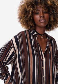 Long-sleeve, button-up shirt in vertical brown, cream, and navy stripes. Soft material with a relaxed fit and collared neckline.