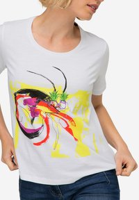 Weißes Baumwoll-T-Shirt mit buntem abstraktem Design in Pink, Gelb und Schwarz, runder Ausschnitt und kurzen Ärmeln.