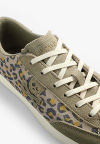 Grüne Wildleder-Sneaker mit Akzenten in Leopardenmuster in Beige, Blau und Gelb. Mit weißen Schnürsenkeln und einem Totenkopf-Logo-Detail an der Seite.