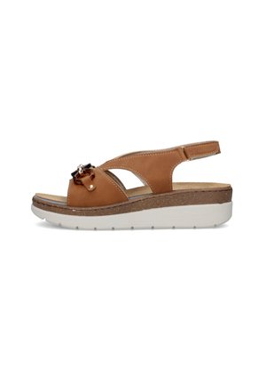 Sandalo con zeppa in pelle marrone con punta aperta, cinturino posteriore e fibbia decorativa in tartaruga su suola bianca.