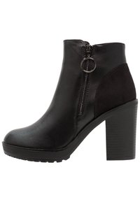 Stivaletti neri alla caviglia in pelle liscia con un accento in suede, dotati di zip laterale e un tacco spesso e texturizzato.