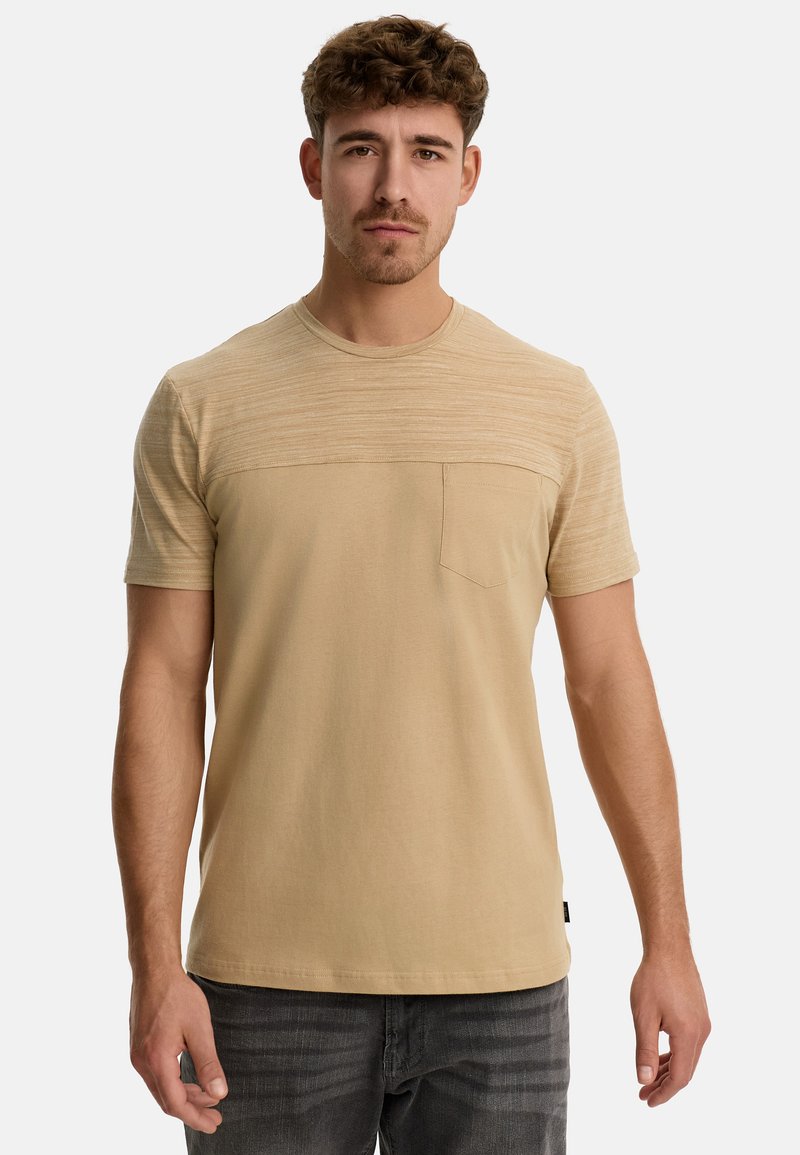 Kortærmet beige t-shirt med et struktureret overpanel, rund hals og en lille brystlomme, lavet af blødt, let materiale.