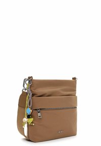 Brązowa nylonowa torba na ramię z regulowanym paskiem, wyposażona w przednią kieszeń na zamek, ozdobne zawieszki oraz akcenty w kolorze srebrnym.