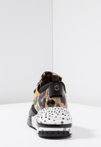 Baskets multicolores avec une tige texturée noire et jaune, une semelle intermédiaire blanche tachetée et un talon à motif. Dotées d'une languette pour un enfilage facile.