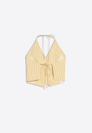 Béžový halter top s tenkými vertikálnymi pruhmi, hlbokým výstrihom do V, otvorenými stranami a predným zaväzovaním, položený na bielom pozadí.