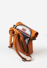Brauner Leder-Rucksack mit Rollverschluss, ausgestattet mit einem grauen Innenraum, roten Reißverschlussakzenten und verstellbaren Trägern. Seitenreißverschluss-Tasche sichtbar.